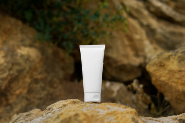 White mockup of a tube of cream on a limestone rock. The concept of natural cosmetics for the face...