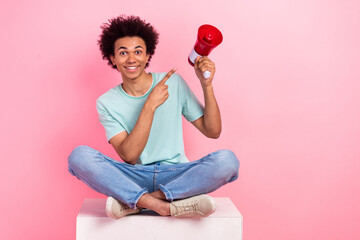 Full size photo of nice young guy sit podium point loudspeaker wear trendy blue outfit isolated on pink color background - obrazy, fototapety, plakaty
