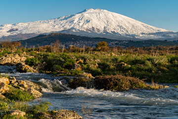 A seasonal river flows under the massive snowcovered Etna volcano. Favare Santa Venera 