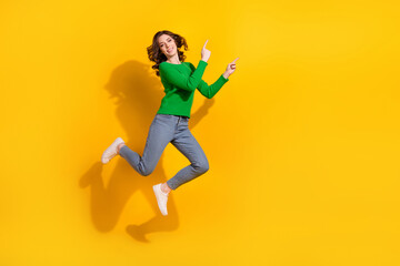 Full body photo of young brunette girl in stylish outfit jump carefree point fingers novelty hot sale isolated on yellow color background