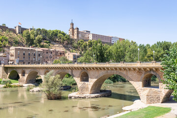 Sant Miquel old bridge over Segre river with a view to the Sant Crist in Balaguer, comarca of Noguera, Province of Lleida, Catalonia, Spain - obrazy, fototapety, plakaty