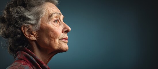 Mature woman with a sad expression, side view, blank area. - obrazy, fototapety, plakaty