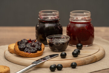 Blueberry jam on wooden plate with knife and bread. Made in Sicily