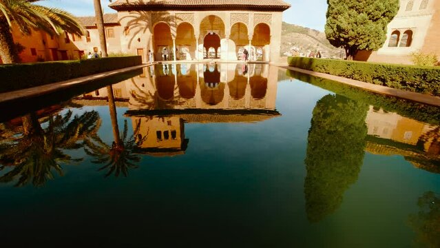 The Alhambra Palace - The Tower of the Ladies beautifully reflected in a pool of the Partal Gardens, Nasrid Palaces, Granada, Andalucia, Spain