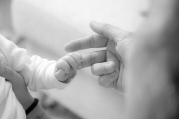 Les doigts du bébé qui tiennent la main de ses parents