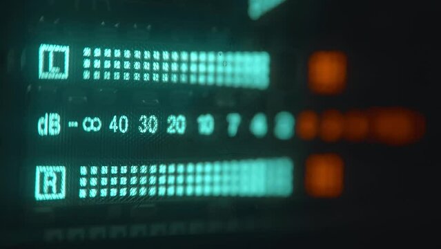 The level indicator of а music from professional recorder is glows blue and shows the decibel range and overload area with high accuracy. Closeup. Macro. Shallow depth of field