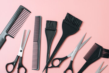 Set of hairdresser tools on a pink background.