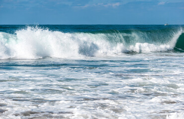 Big Waves crashing creating white foam that vaporises in the air. Sopelana beach near Bilbao. Surfers waiting for the perfect wave. Day of relaxation and tranquility.