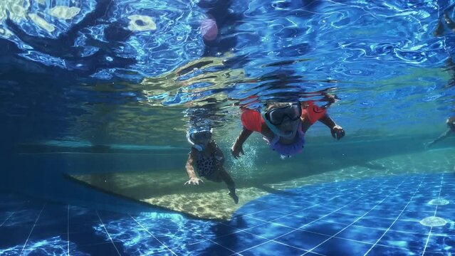 Two little girls swimming in a pool with a snorkel