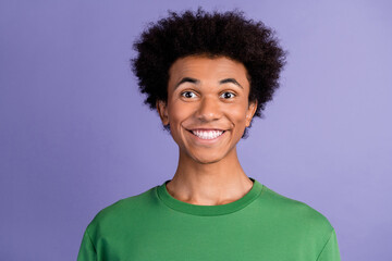 Photo of cheerful funky guy wear green pullover smiling showing white teeth isolated purple color background
