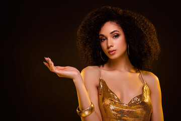 Portrait of stunning gorgeous girl hold empty space dressed stylish golden garment isolated on...