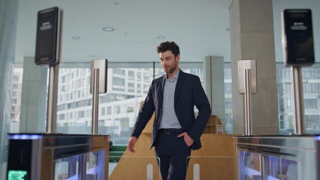Confident businessman passing electronic gates with face recognition system.