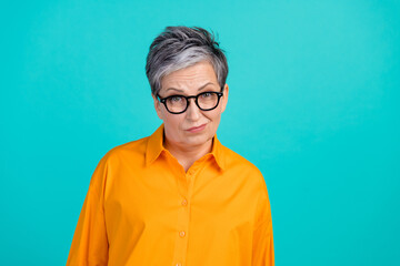 Photo of suspicious distrustful business woman old grandmother raise eyebrows wear orange shirt isolated on aquamarine color background - obrazy, fototapety, plakaty