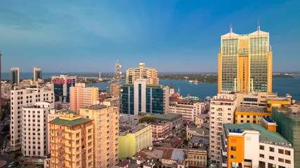 Foto op Plexiglas Cityscape of Dar es Salaam at sunset featuring residential and office buildings. © STORYTELLER