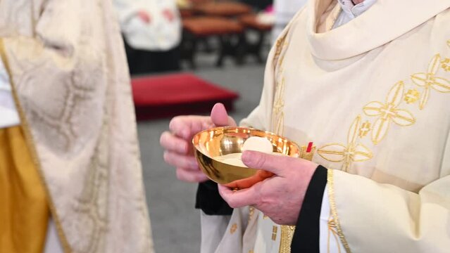 Catholic priest gives holy communion to prayers in cathedral. Midnight Holy Mass on Christmas Eve. Prayer receive the host or bread in church. Eucharist. Sacramental bread.