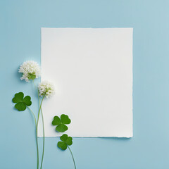 Clover on a blue background with a white sheet of paper for text. Holiday greetings concept.