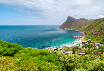 Secluded beach village of Smitswinkel Bay surrounded mountain and lush forest, cape peninsula, Cape Town, South Africa