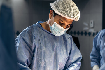 A skilled male surgeon performing a meticulous scoliosis surgery in a medical facility