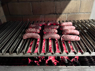 Chorizos on the grill. Argentine chorizos. Grilling chorizos over charcoal. Grill with sausages.