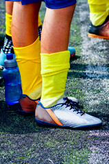 Detail of a child football player's legs on an artificial grass field