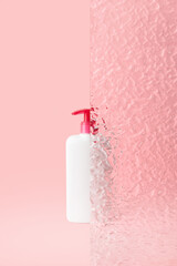 Bottle of intimate hygiene gel on pastel pink background. Beauty treatment concept.