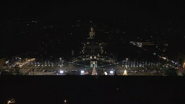 Aerial Drone Night view of Christmas, Winter Festival of Chisinau in City Center. Christmas Tree, Government House of Moldova, The Great National Assembly Square, Road. Republic of Moldova 4K