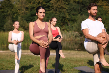 Group of people practicing yoga on mats outdoors