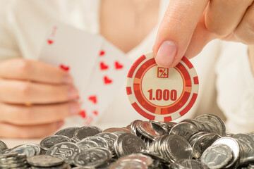 hand with poker chip and coins