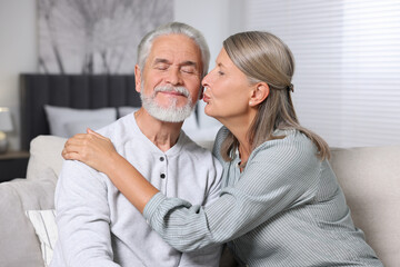 Senior woman kissing her beloved man at home