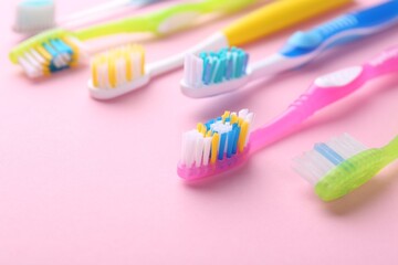 Many different toothbrushes on pink background, closeup. Space for text