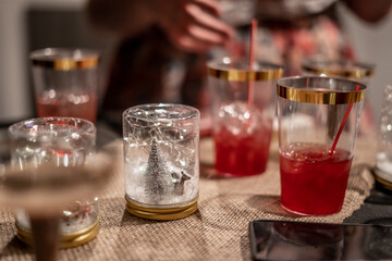 Bunch of Red Drinks Gold Rim Cups Christmas Decorations on Table