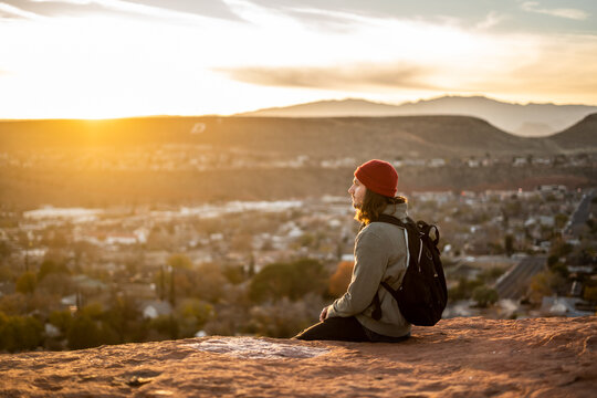Portrait Person With Bright Red Beanie in St George, Utah Dixie Rock wearing Backpack Outside Sunset Golden Hour Red Rocks