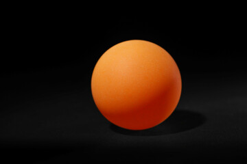 One ping pong ball on black background