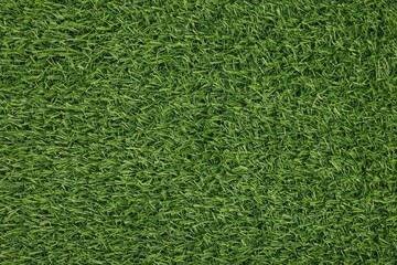 Fototapeta premium Green artificial grass as background, top view