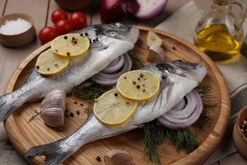 Fototapeta na wymiar Raw dorado fish with lemon, spices and onion on table, closeup