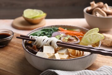 Bowl of vegetarian ramen and chopsticks on table, closeup
