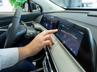 Close-up of a man's hands on the dashboard of a modern car. 