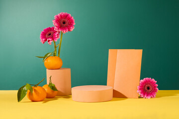 Pink gerberas stand out among pastel platforms with tangerines and lucky money envelopes against a...
