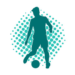 Silhouette of a male soccer player kicking a ball. Silhouette of a football player in action pose.