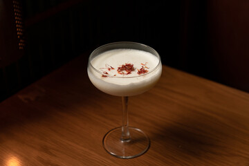 Alcoholic herb cocktail on top with safflower. Serving summer cocktail in bar. Creative cocktail in Asians style. 	