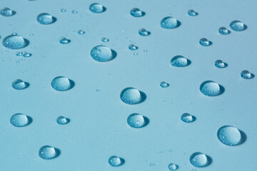 Water background with drops on blue surface, wet pattern. Spa concept, texture of cosmetics, gel, serum. Water spray, banner