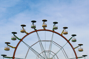 Ferris wheel with cloudy blue sky background