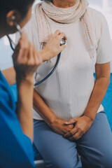 Close up of Female Doctor using stethoscope putting beat heart diagnose with patient in examination room at a hospital, check-up body, Medical and Health Care Concept.