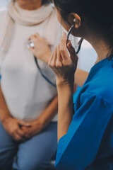 Close up of Female Doctor using stethoscope putting beat heart diagnose with patient in examination...