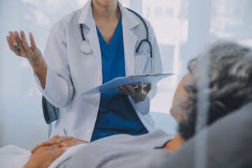 Women Asian doctors hold the patient hand and encourage and provide medical advice While checking...