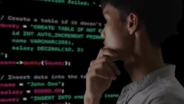 Young man programmer analyzing programming language PHP, Html, Database for website used for collecting data and publishing reports. He find errors in the system and he is comfortable with programming