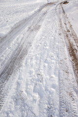 Fototapeta na wymiar Tire tracks in the snow, mud on the roads