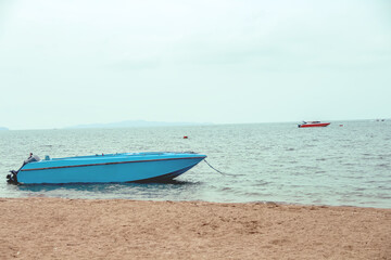 Fototapeta na wymiar Blue boat moored in sea beach on sky and mountain view background
