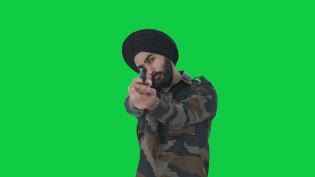 Serious Sikh Indian Army man pointing gun towards enemy Green screen