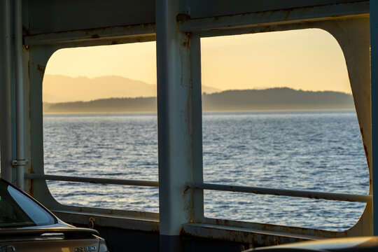 Fototapeta hazy yellow sunset seen at an angle through an old metal washington state ferry window